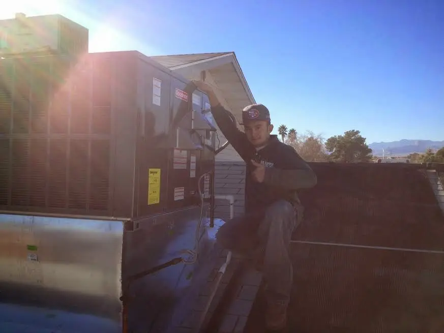 HVAC technician performing Heat Pump Repair on a rooftop unit in Cottonwood